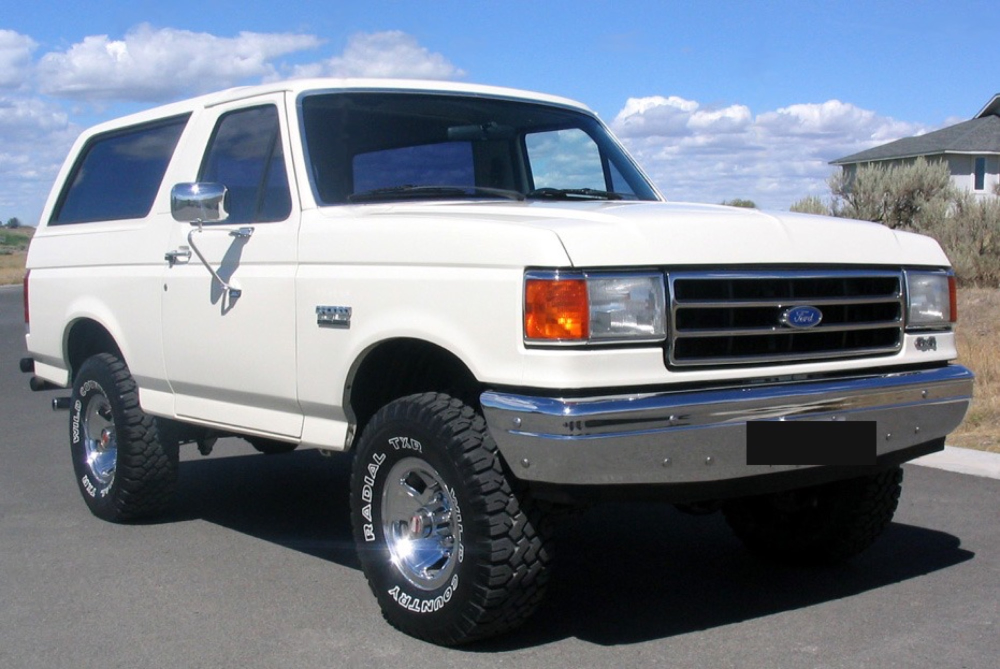1990 Ford Bronco, white, lifted, front 3/4 view